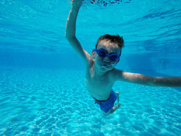 istock Child boy swimming pool water playing summer vacation fun 959162466