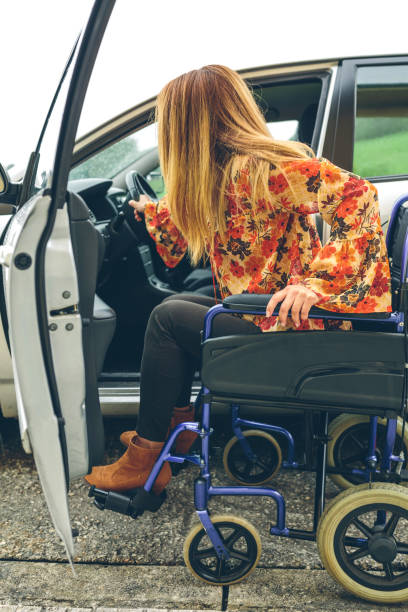 istock Woman in wheelchair getting on car 959166904