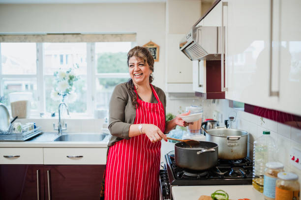 maduras mulher gostar de cozinhar em casa - adult woman - fotografias e filmes do acervo