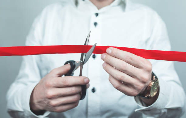 istock Man cutting red ribbon with scissors. 959176350