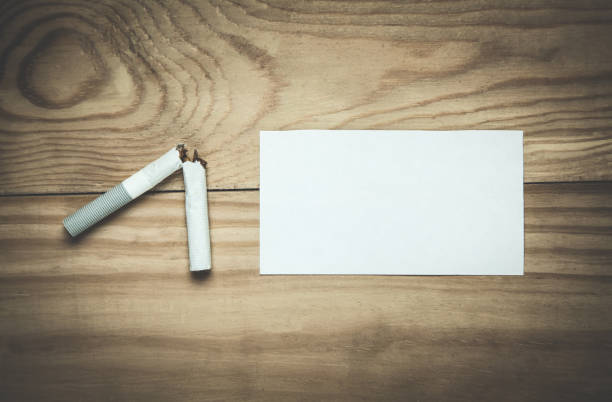 istock Broken cigarette with blank paper on a wood background. 959176582