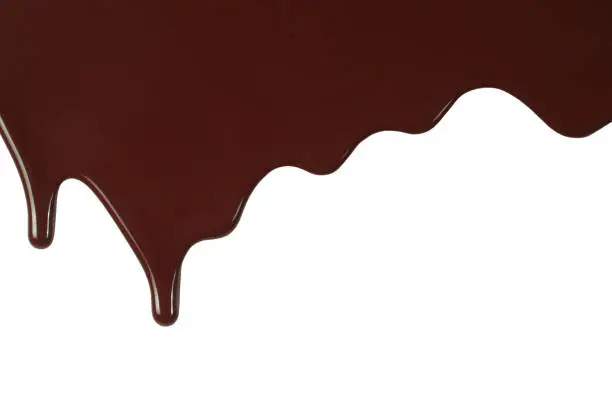 Melted chocolate dripping on white background close-up