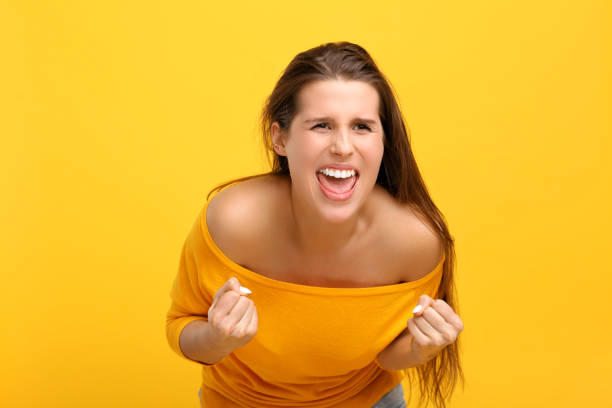 istock Woman against yellow wall background 959180704