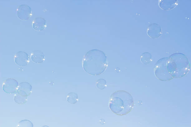 istock Many large soap bubbles flying in blue sky 959180926