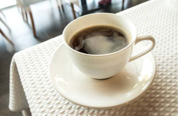 istock cup of coffee over white table background 959181172