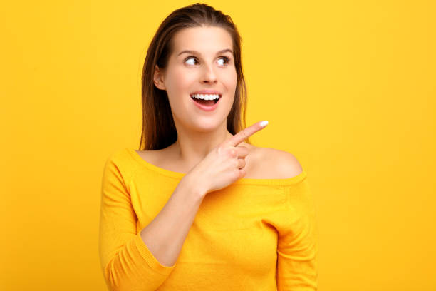 istock Woman against yellow wall background 959181248