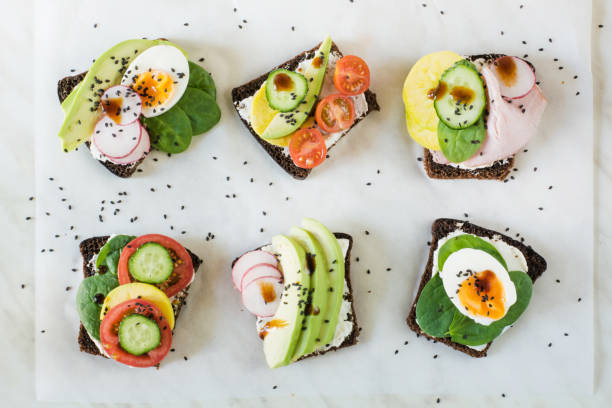 istock Different sandwiches with vegetables, eggs, avocado, tomato, rye bread on light marble table. Top vew. Appetizer for party. Flat lay. 959181762