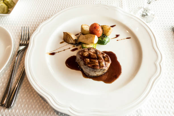 istock medium rare grilled Beef steak Striploin and salad on white plate isolated 959185054