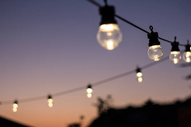 Party Time Outdoor string lights hanging in line. light strings stock pictures, royalty-free photos & images