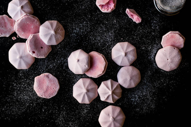 istock Pink Meringues with Powdered Sugar on Black Surface. 959186420