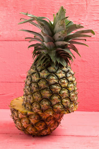istock pineapple half on pink wood 959186602