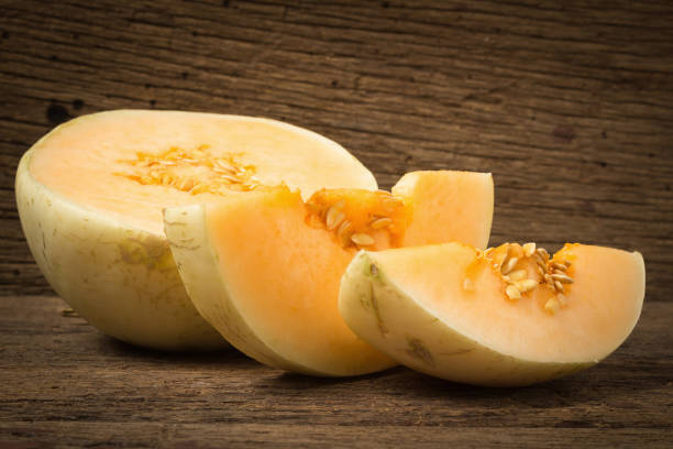 istock melon (sunlady) slice. half. on old wood. morning 959186642