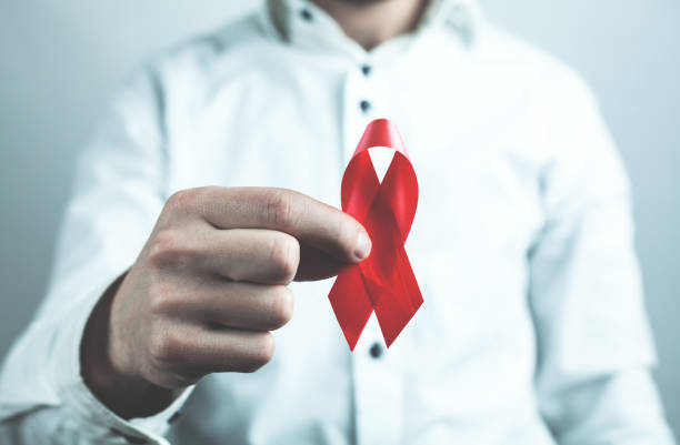 istock Man showing red ribbon. AIDS awareness sign. 959198288