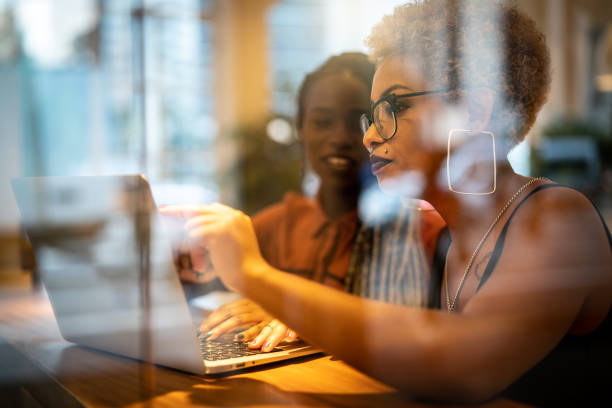 Two Business woman meeting through window