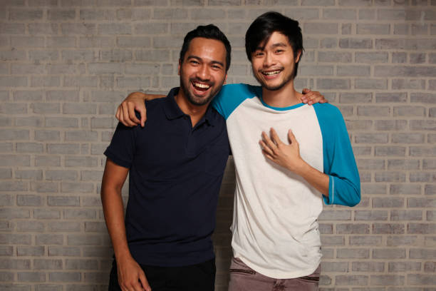 istock Two Male Friends With Arms Around Each Other 959206738