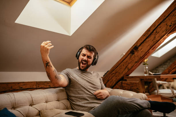 Unwinding with some music Young man listening to the music at home air guitar stock pictures, royalty-free photos & images