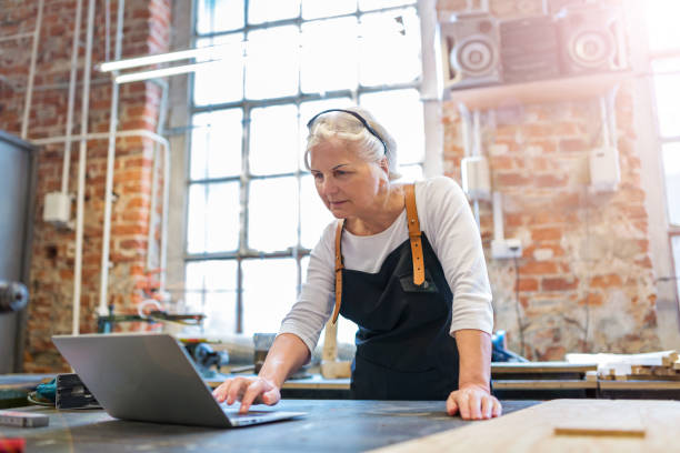 istock Senior woman using a laptop in a workshop 959213114