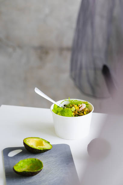 Green salad to go in white paper bowl