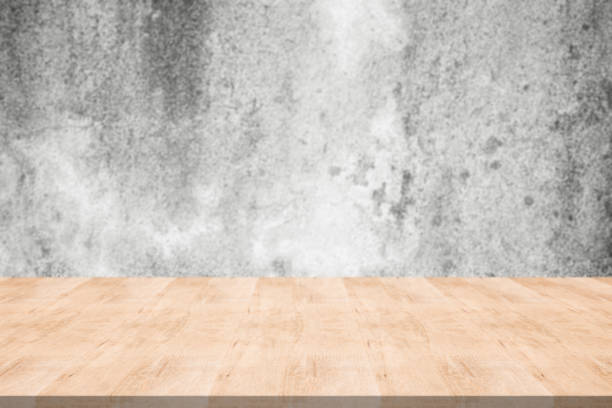 istock Wood table top on blurred background from concrete wall, Space for montage your products 959237212