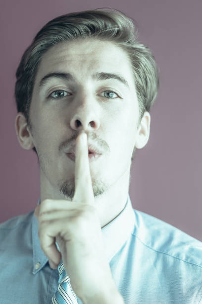 istock Mysterious young businessman with finger on lips 959243434