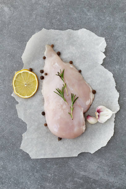 raw chicken breast with spices, garlic, lemon and rosemary on a grey stone table. top view. - garlic chicken breast raw chicken imagens e fotografias de stock