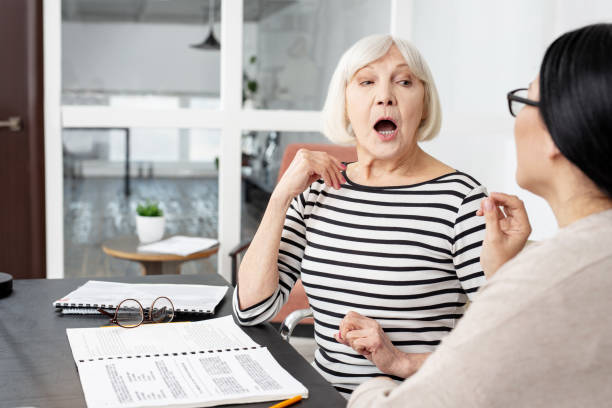 Focused senior tutor demonstrating pronunciation stock photo