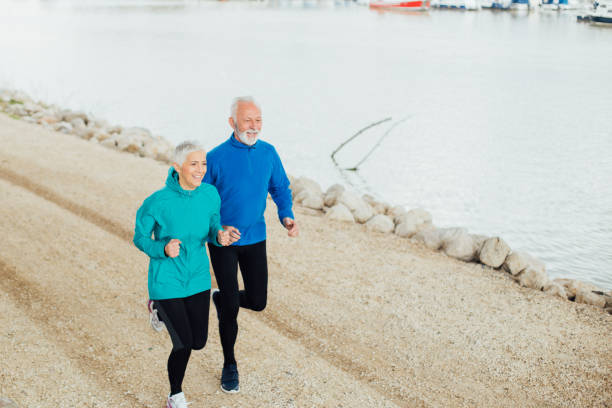 istock Senior couple going for a run by river 959249056