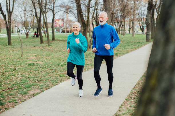 istock Senior fit couple jogging in the park 959251112