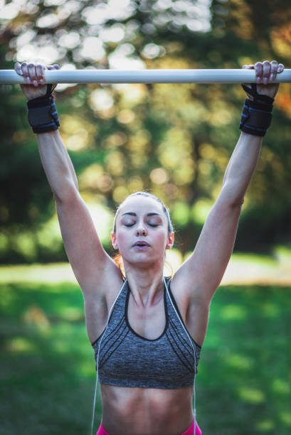 istock Healthy young woman exercising on wall bars during sunset 959251216