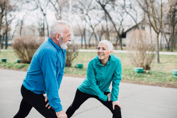 istock Older fit couple stretching legs in the park 959251290