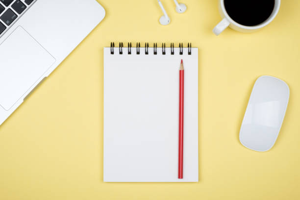 istock Modern yellow office desk table with laptop and blank notebook page for input the text. Top view, flat lay 959251698