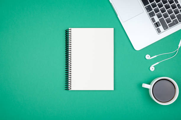 Minimal workplace with laptop and blank notepad on colored background. Top view. Flat lay