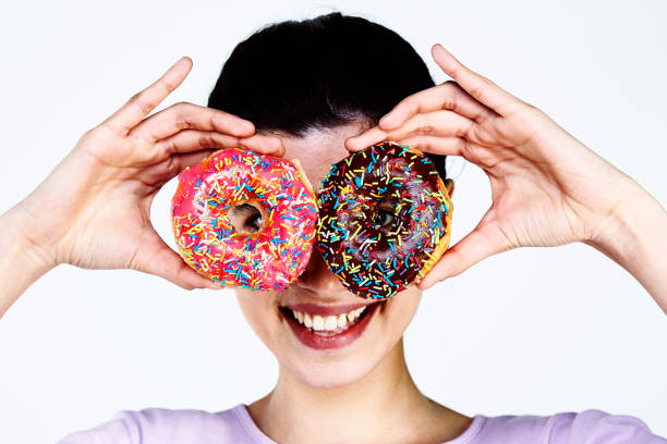 istock Young Woman holding donut 959252114