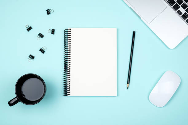 istock Modern blue office desk table with laptop and blank notebook page for input the text. Top view, flat lay 959252222