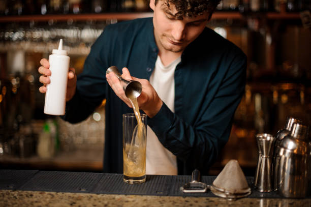 istock Young bartender pouring a sweet syrup into a glass 959252606