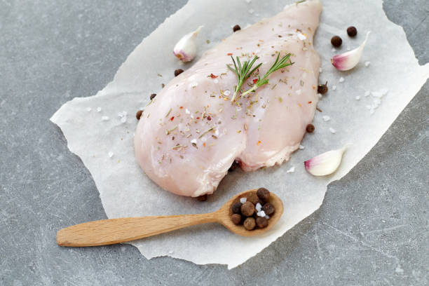 raw chicken breast with spices, garlic and rosemary on a grey stone table. top view. - garlic chicken breast raw chicken imagens e fotografias de stock