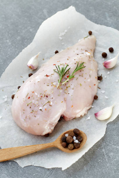 raw chicken breast with spices, garlic and rosemary on a grey stone table. top view. - garlic chicken breast raw chicken imagens e fotografias de stock