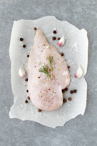 raw chicken breast with spices, garlic and rosemary on a grey stone table. top view. - garlic chicken breast raw chicken imagens e fotografias de stock