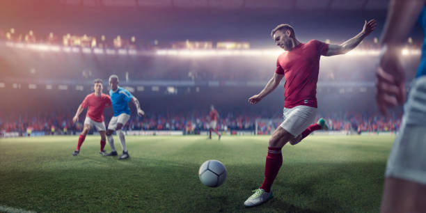 Professional Soccer Player About To Kick Football During Soccer Match A professional male soccer player with foot back and arms out about to kick football in a volley during a soccer match. The player is dressed in generic red and white soccer kit and is near other players who are playing in a game on a generic outdoor soccer pitch. soccer player photos stock pictures, royalty-free photos & images