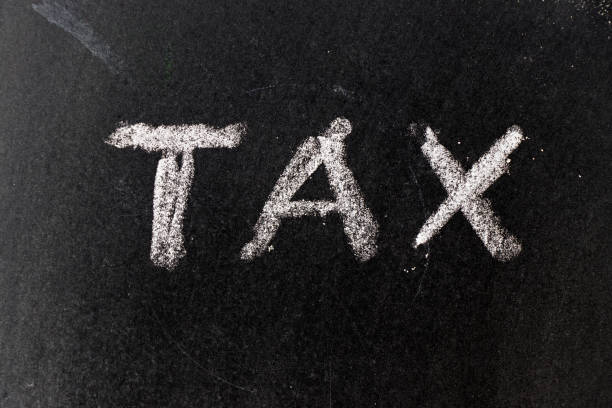 istock White chalk drawing in tax word on black board background 959261602