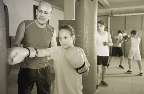 istock Girl with boxing gloves posing in defended stance 959265372