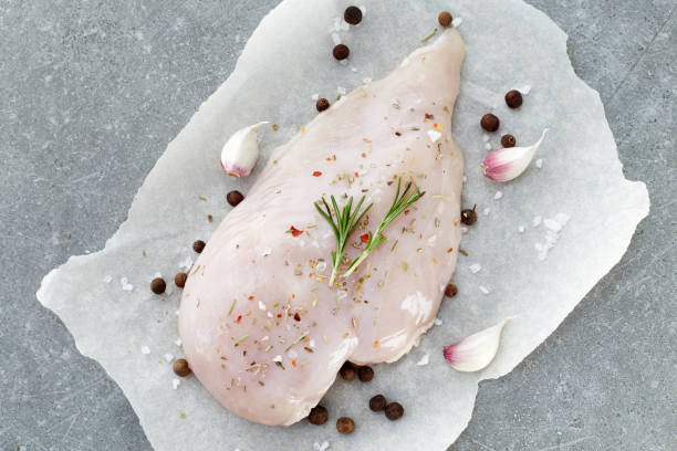 raw chicken breast with spices, garlic and rosemary on a grey stone table. top view. - garlic chicken breast raw chicken imagens e fotografias de stock