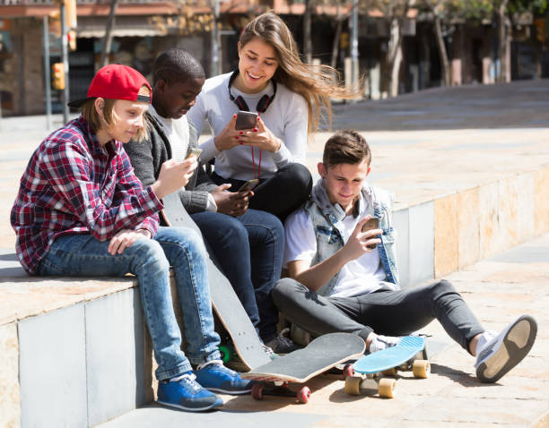 istock Laughing friends with smartphones in spring day 959270388