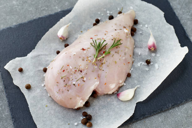 raw chicken breast with spices, garlic and rosemary on a grey stone table. top view. - garlic chicken breast raw chicken imagens e fotografias de stock