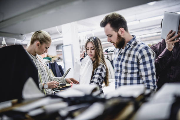 istock Workers In Factory Checking And Correcting New Clothes 959274716