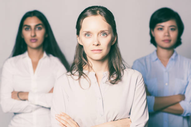 istock Serious young businesswoman standing with team 959286824