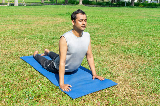 istock Indian man doing upward facing dog pose outdoors 959287450