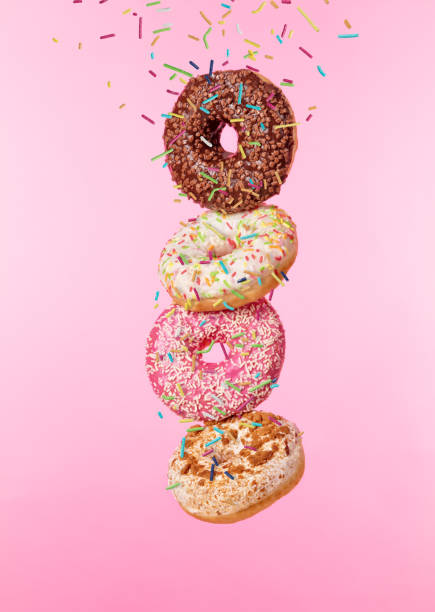istock Flying sweet donuts isolated on pink background. 959289612