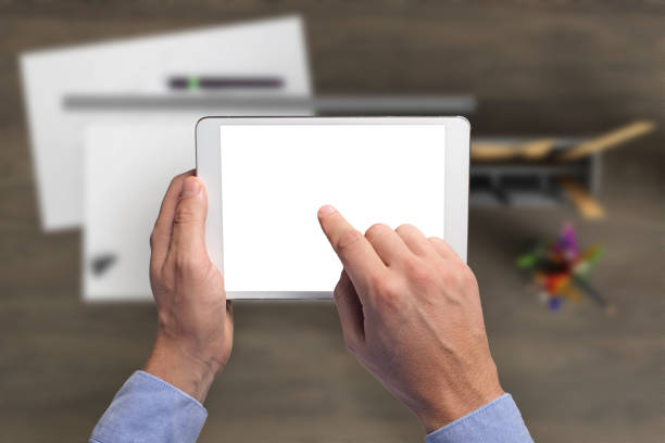 istock Man holding tablet knolling overhead view 959295478