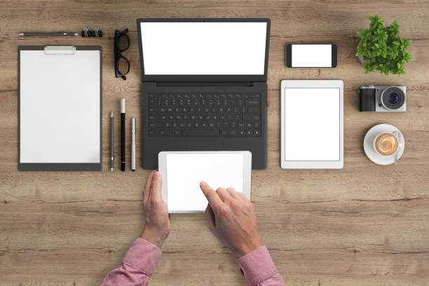 istock Man holding tablet knolling overhead view 959295506